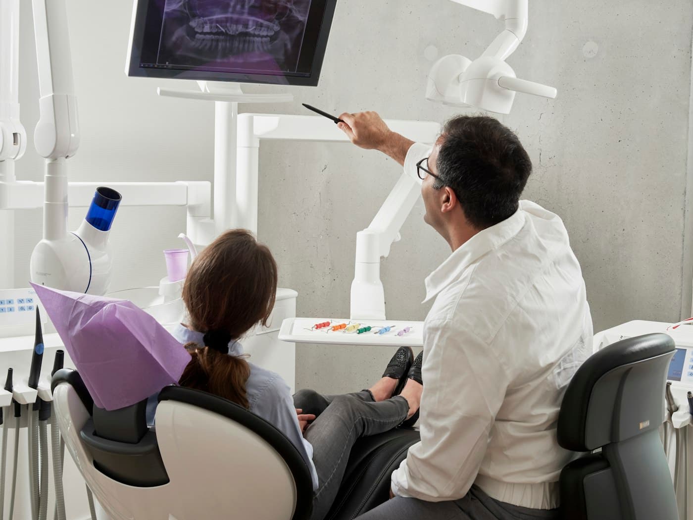 Dentist walking a patient through their X-ray results